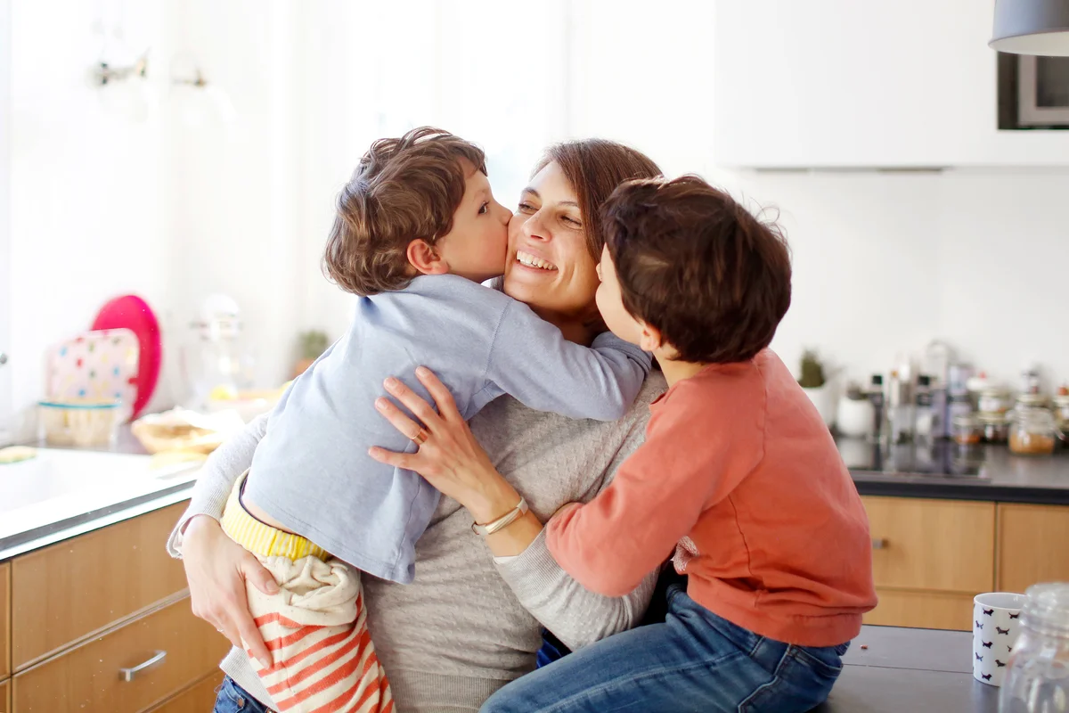 A mom hugging her sons