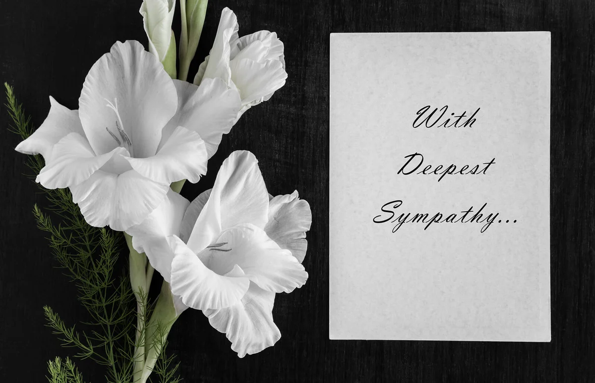 White blank condolence card with text and white gladiolus flower
