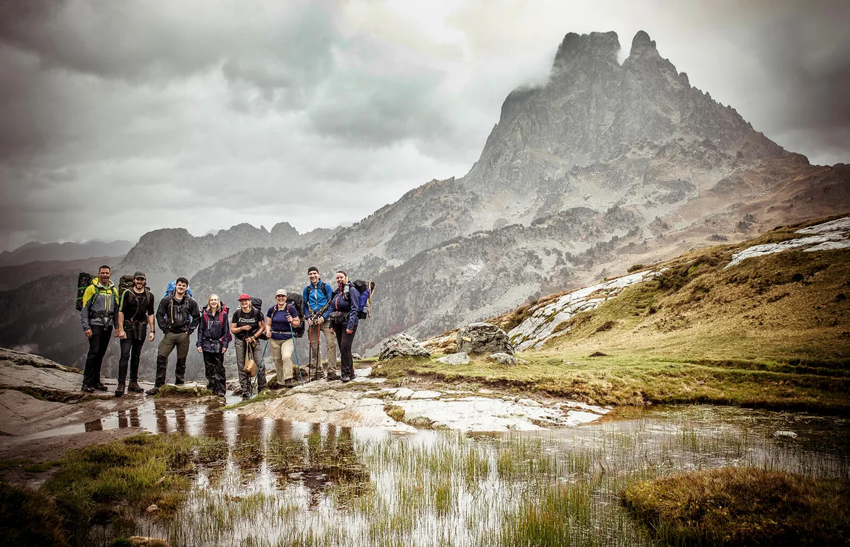 Group of hikers posing by mountain