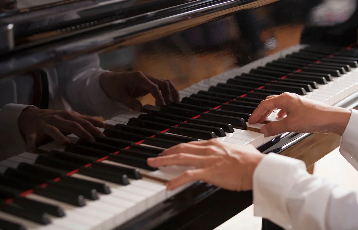 Close up of a pianists hands, playing on a grand piano