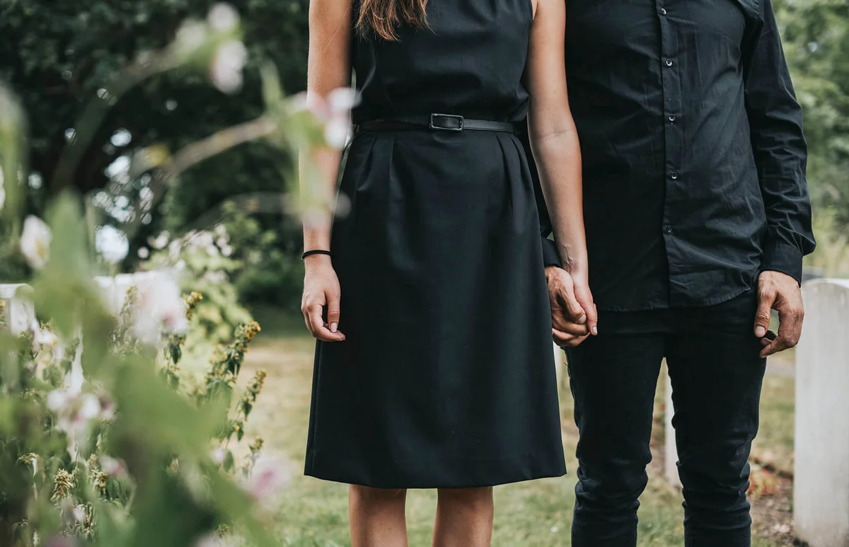 Couple holding hands at a graveyard
