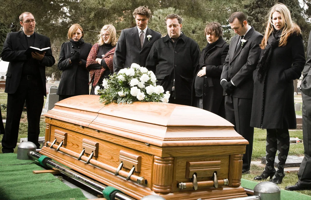 people at a funeral in a cemetery