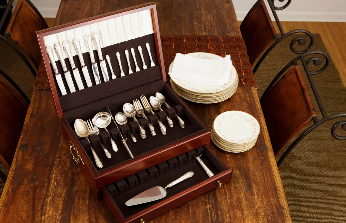 open cutlery box with stacks of plates on a dining table