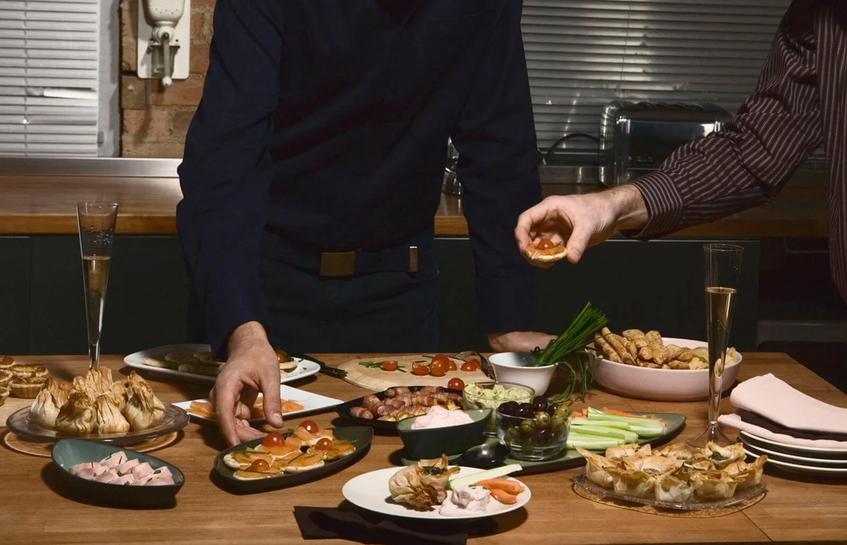 Two young men taking food from buffet