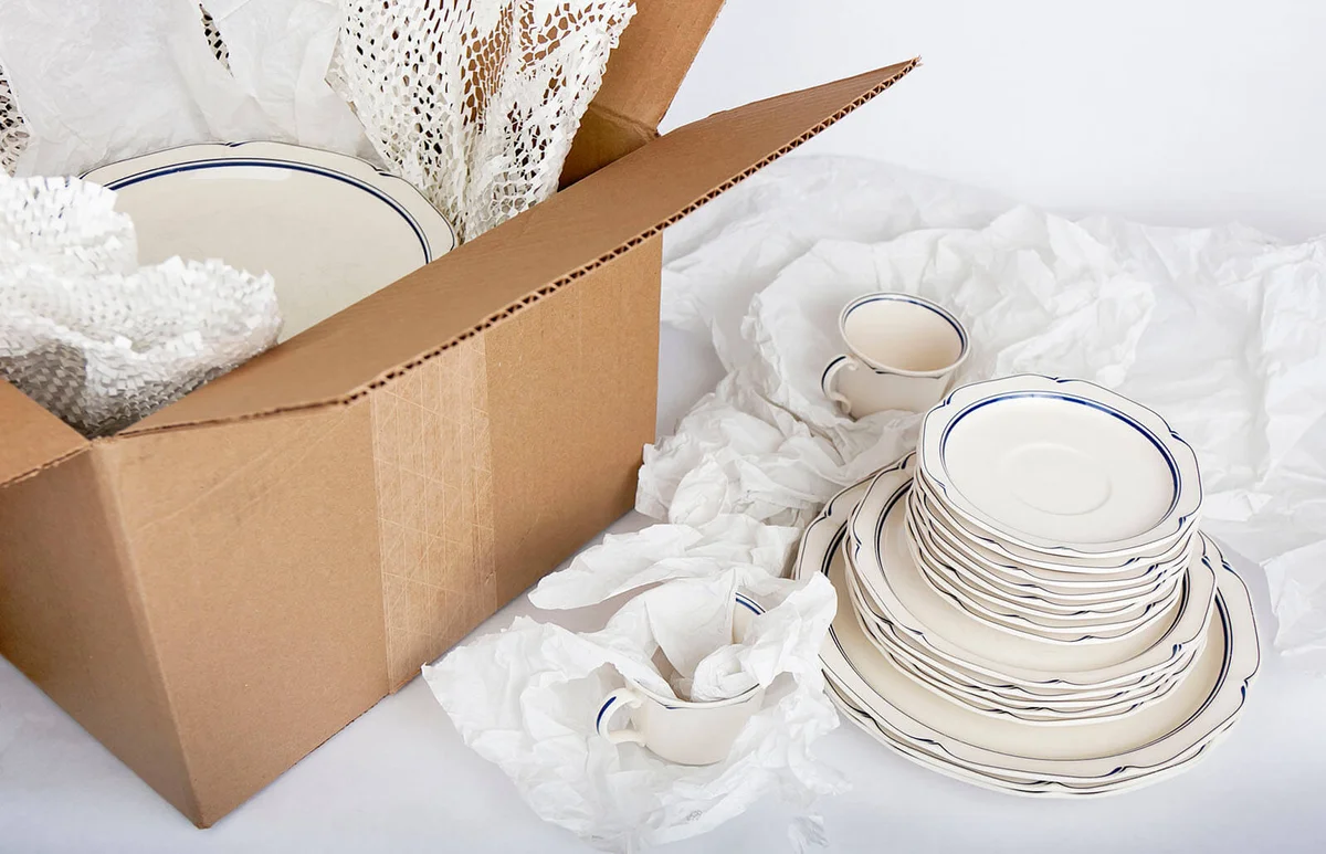 dishes being wrapped in tissue paper
