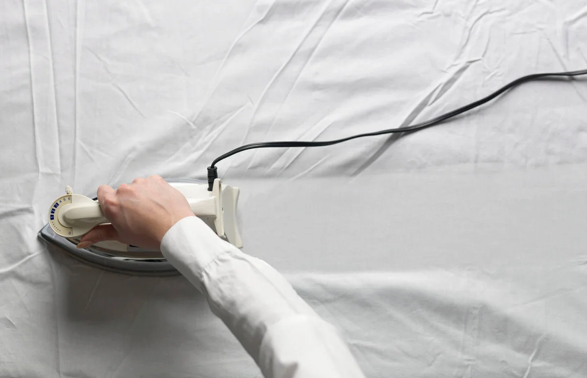 Woman ironing white cloth