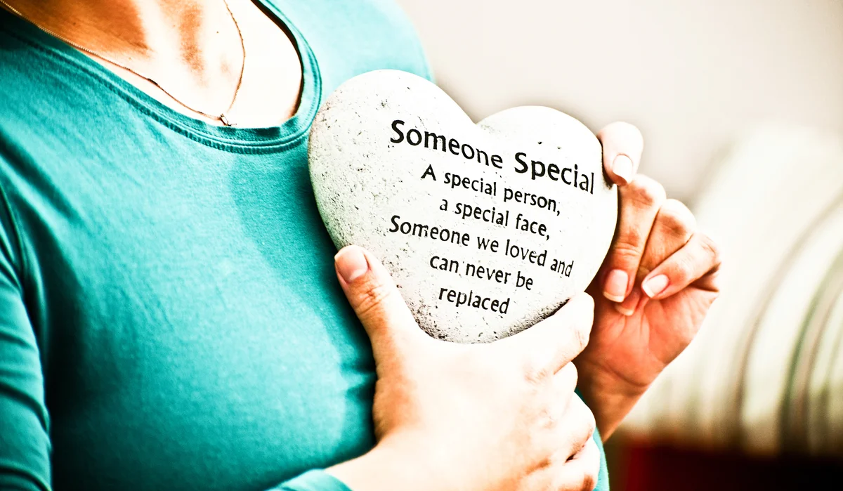 Woman holding a heart tribute in memorial to deceased loved one