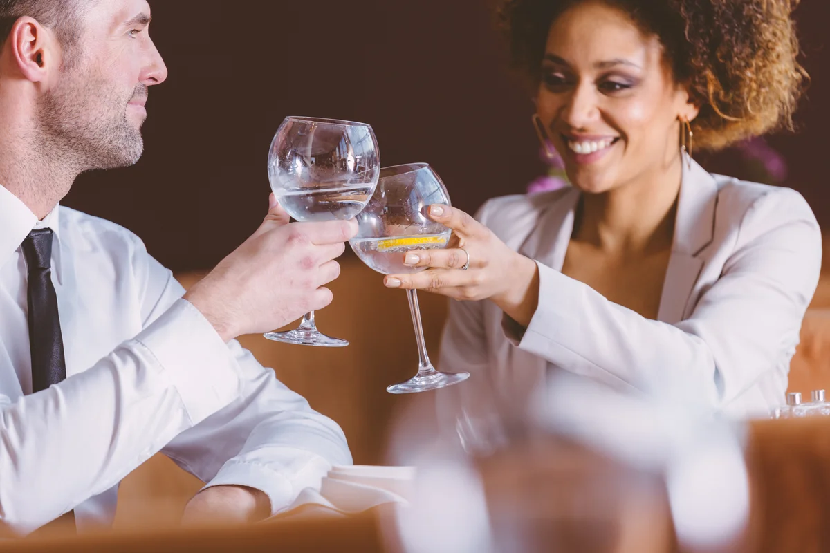 couple toasting each other at dinner