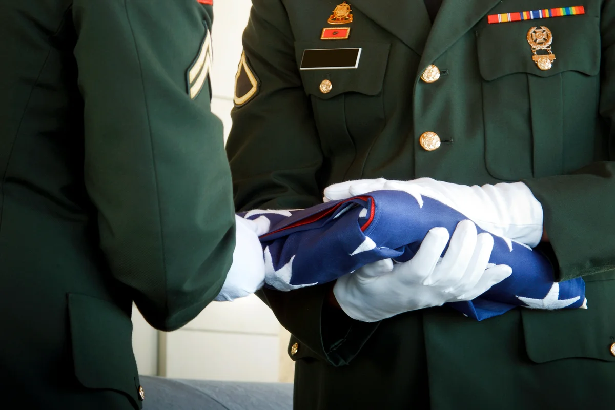 Military Honor Guard Folds United States Flag at Veteran Funeral