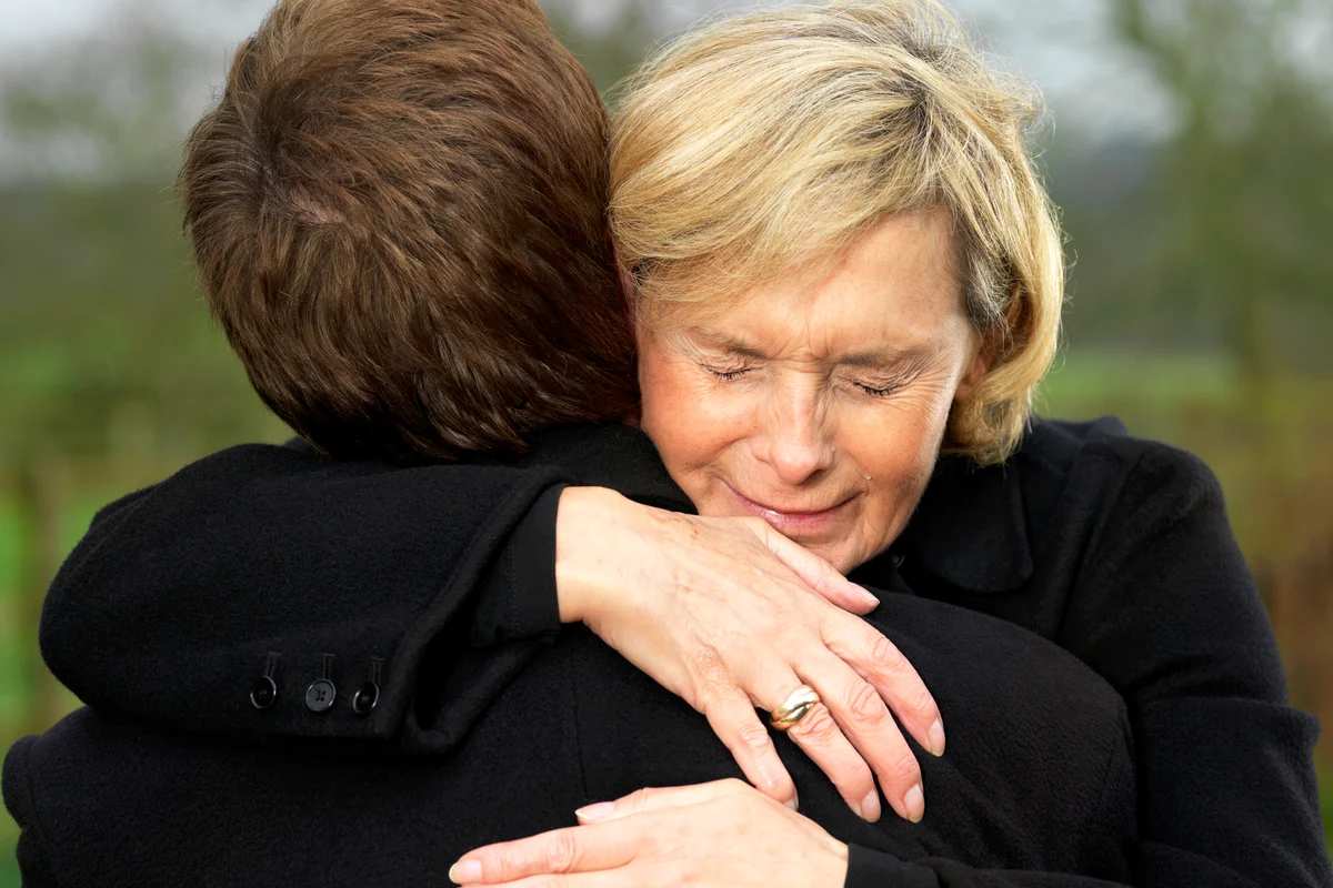 Crying Woman Hugging a Man Before a Funeral