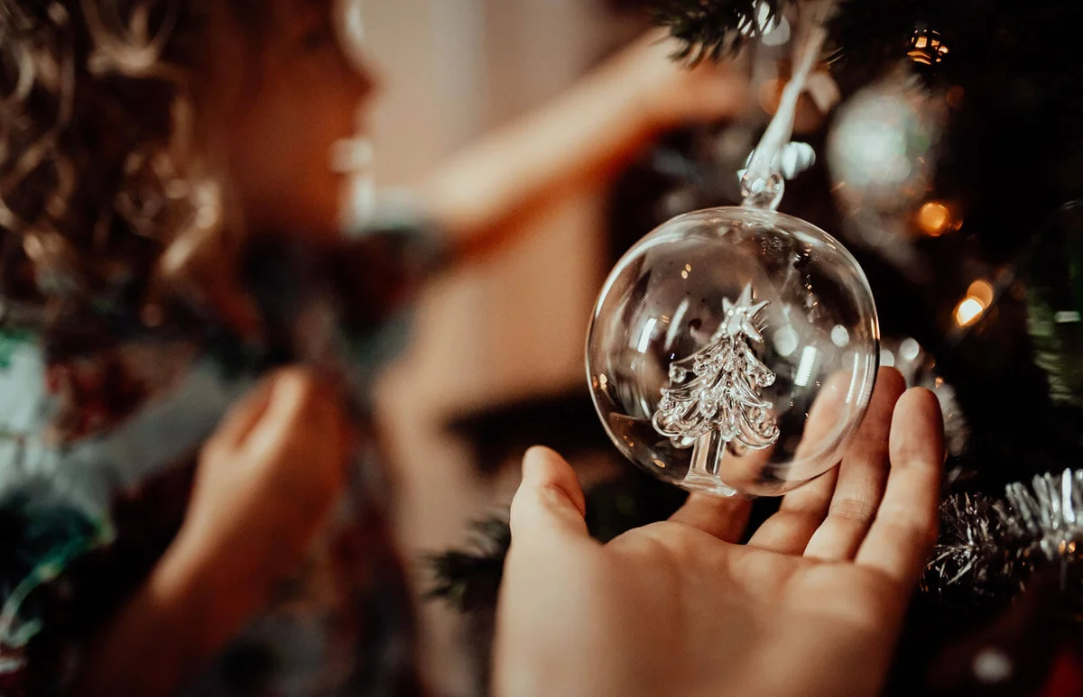 girl admires the Christmas tree ornaments