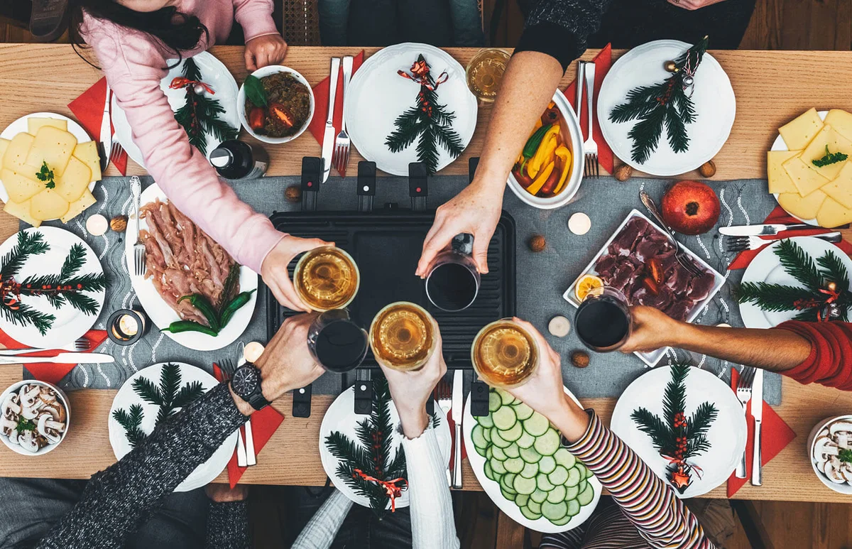 family dinig at wooden table with raclette grill