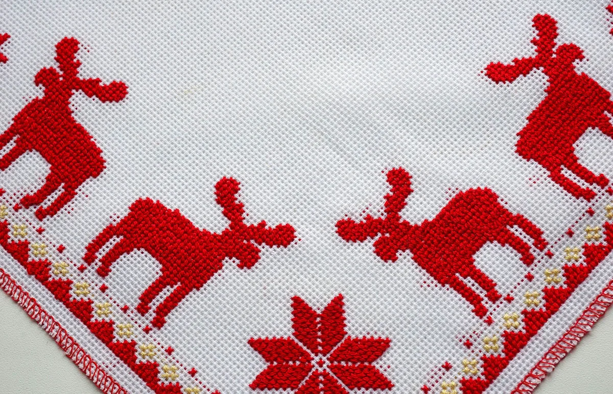 Cross-Stitched red deer on the white tablecloth