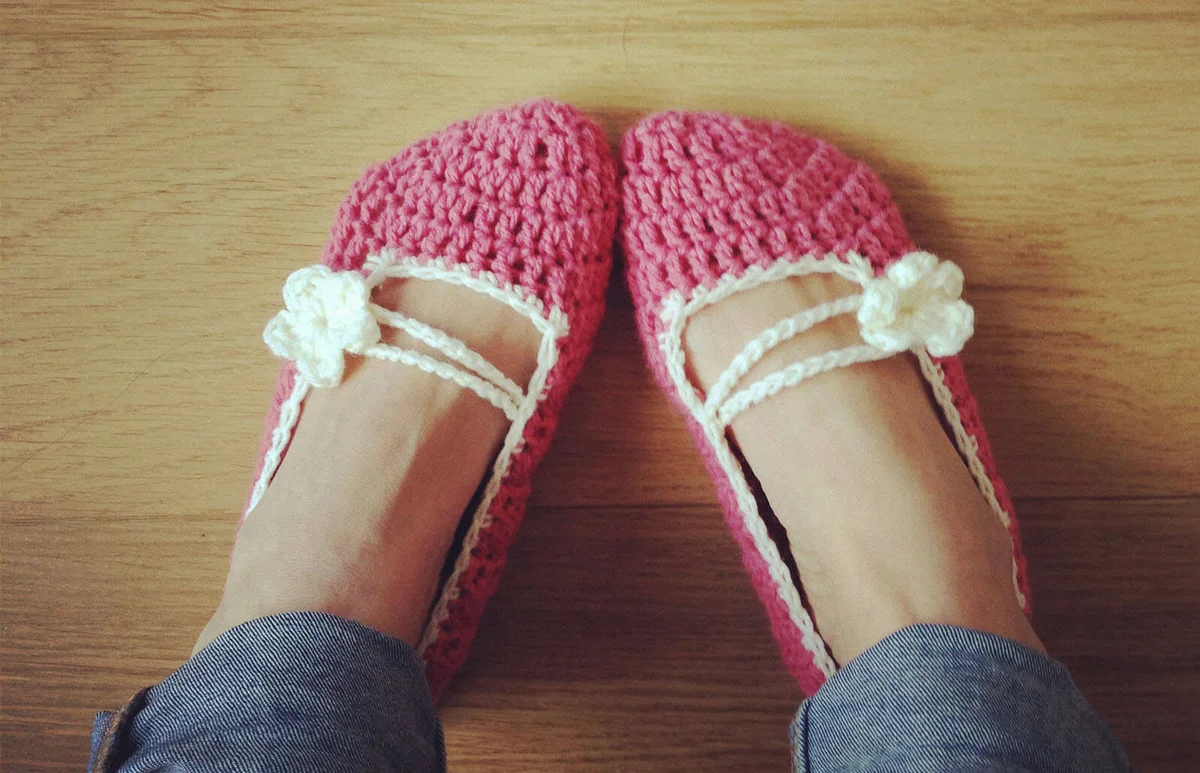 Woman feet wearing a pair of crocheted bed socks