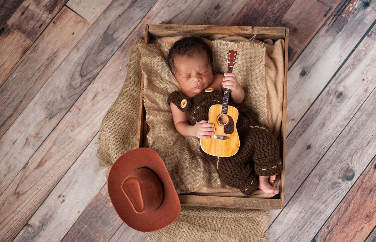 Newborn Baby Cowboy Playing a Tiny Guitar