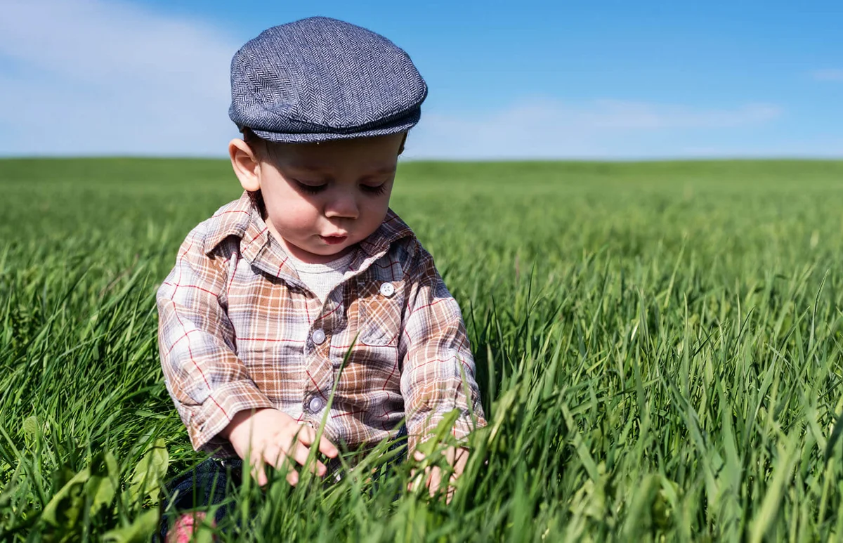 boy enjoys sitting in tall grass
