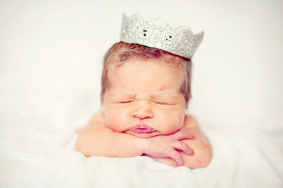 Newborn baby wearing a silver crown