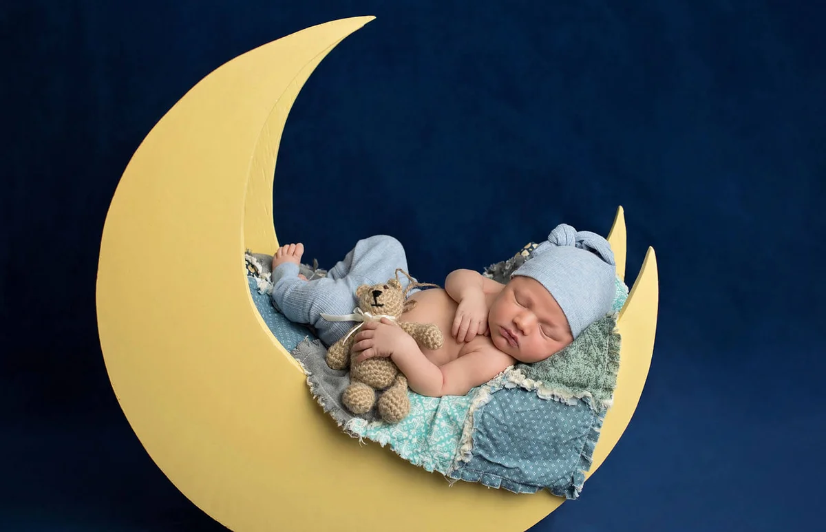 Newborn Boy Sleeping on the Moon with Teddy Bear