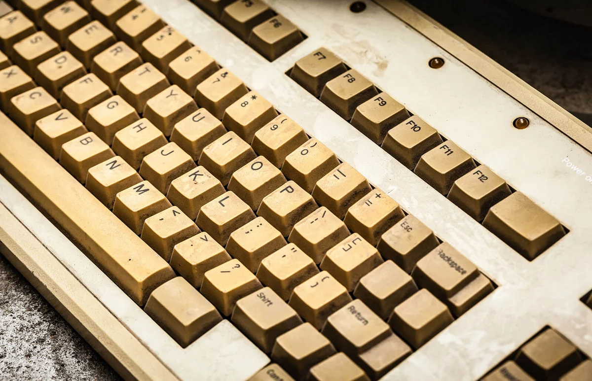 old and yellowed dusty pc keyboard with stains