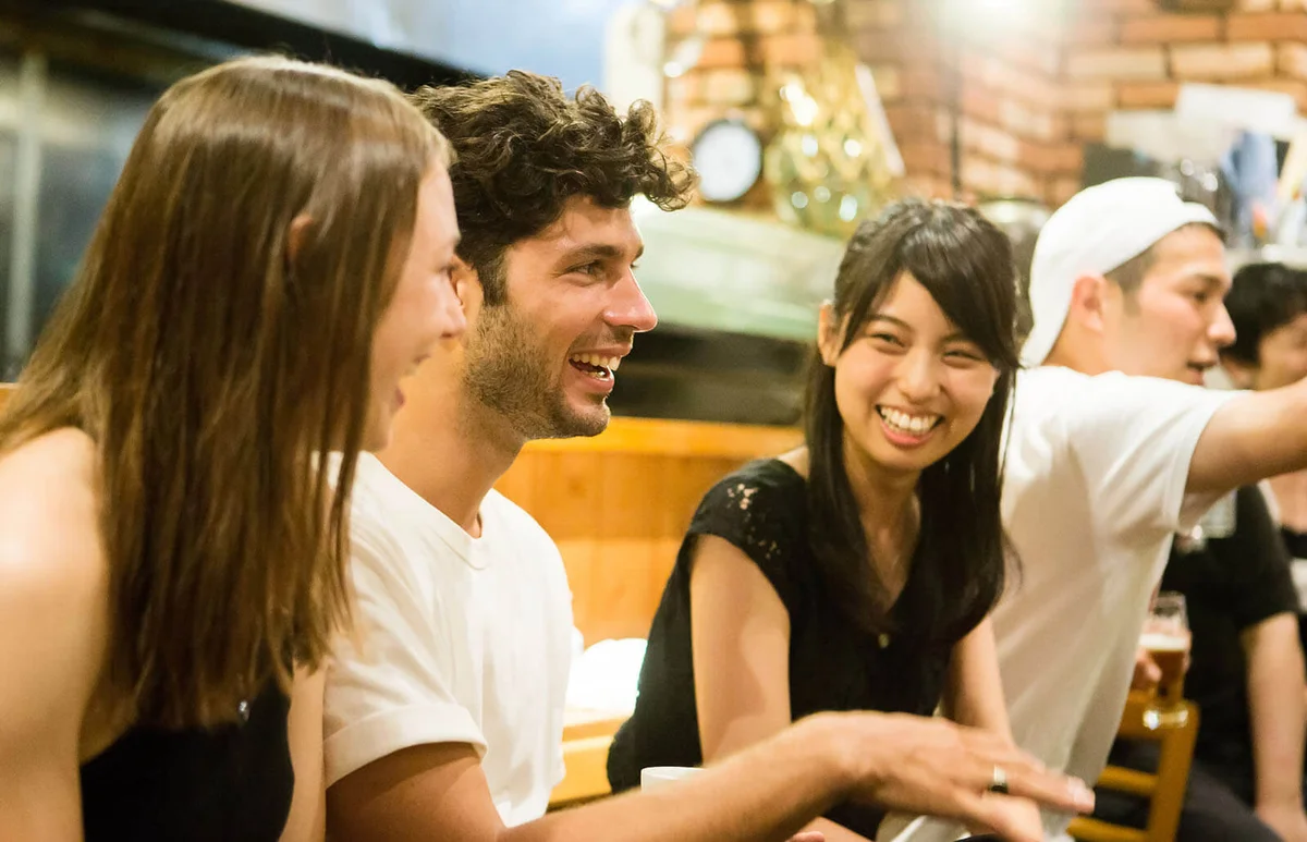 People of various ethnicities interacting at a Japanese pub