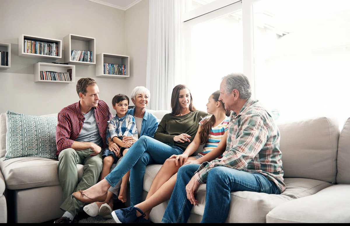 family sitting together on a sofa at home