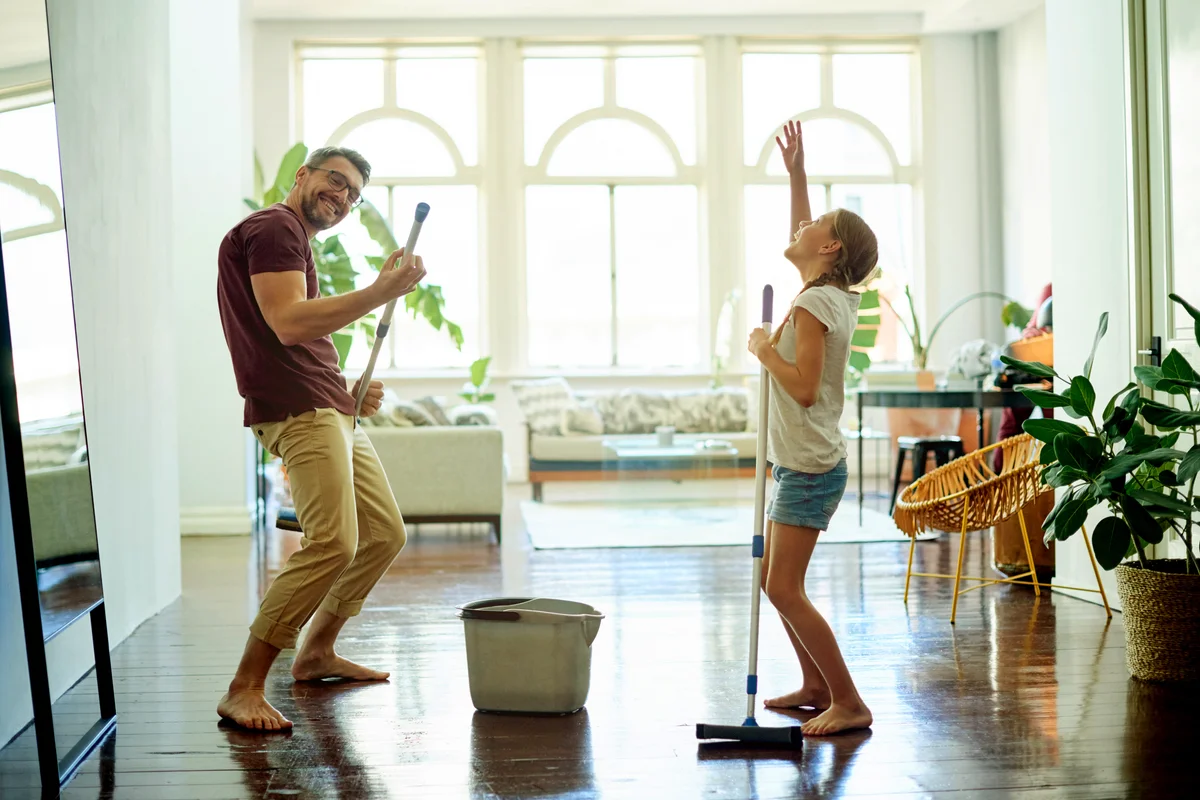 Mature man and his daughter mopping the floors in their home as part of their spring cleaning