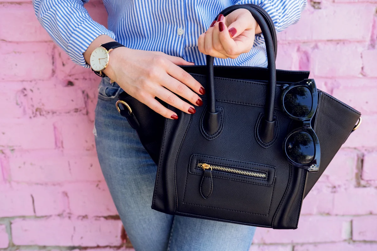 Close up black leather bag in hand of fashion woman