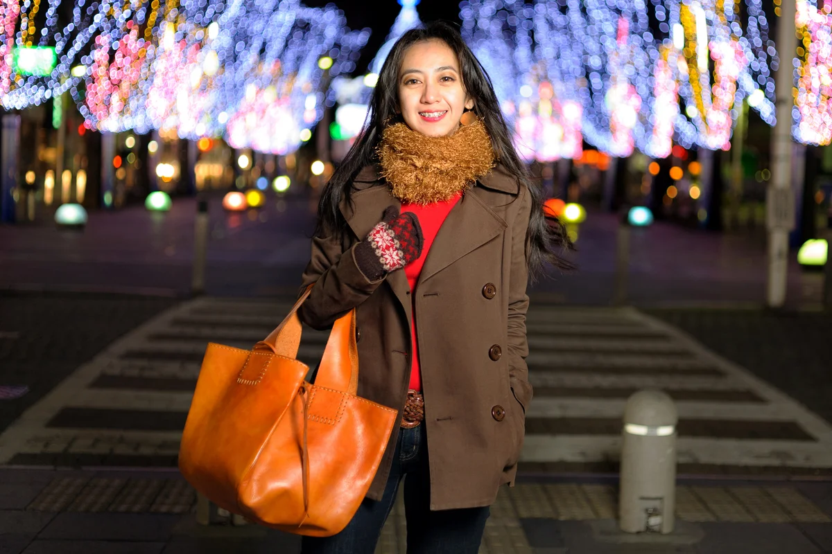 Woman wearing brown coat with leather bag