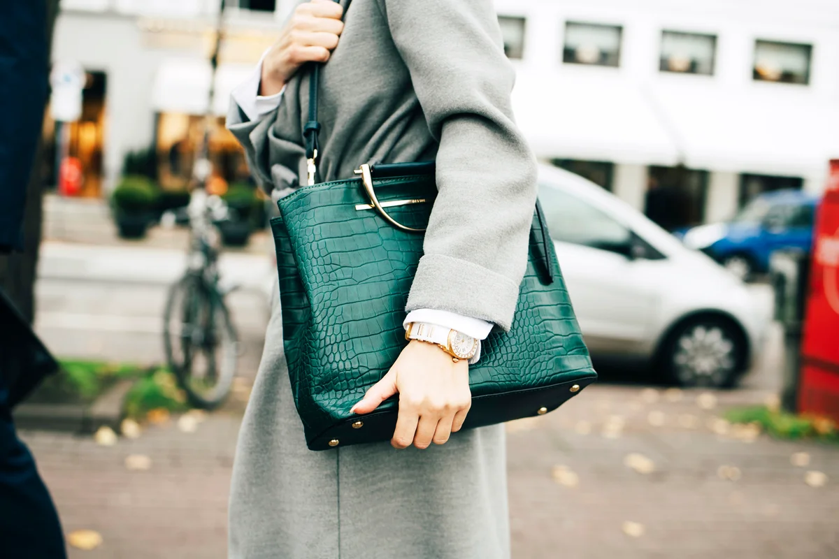Businesswoman with green handbag standing in city