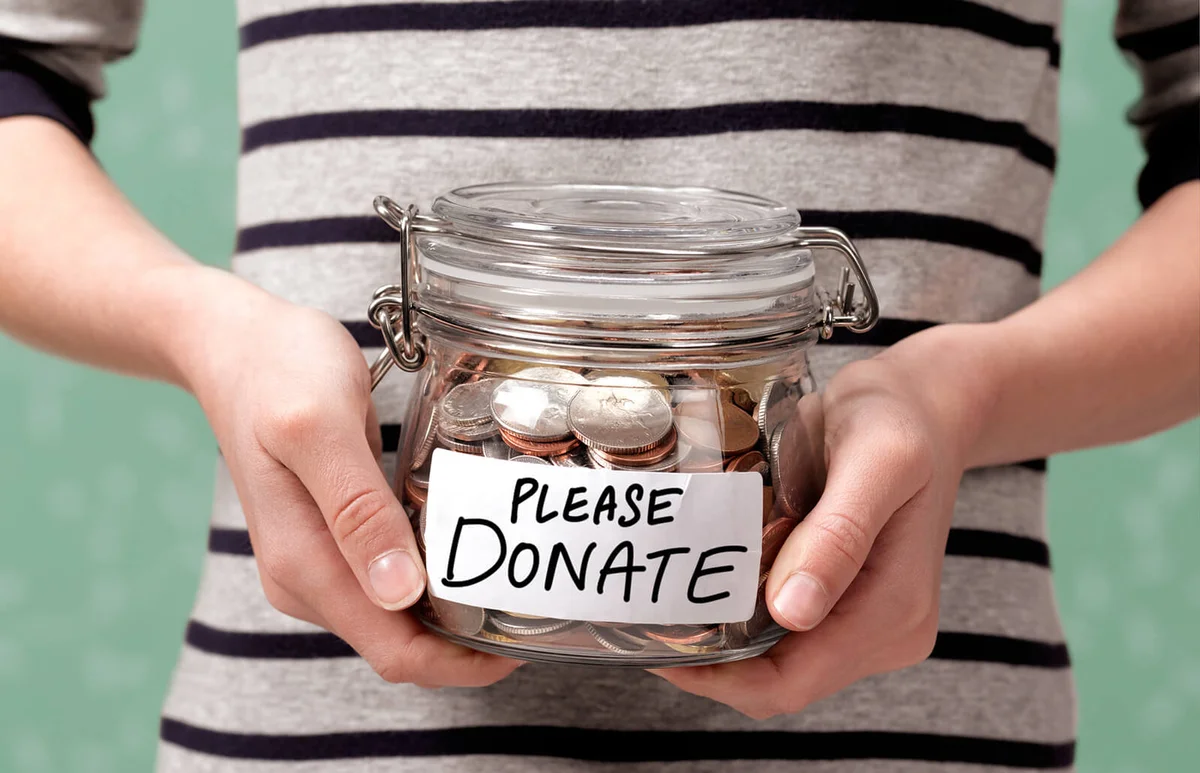 girl holding a charity donation jar