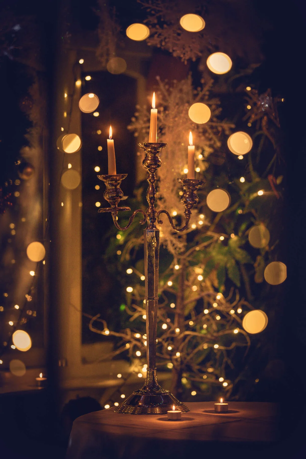 Candlestick on a table in front of a Christmas tree