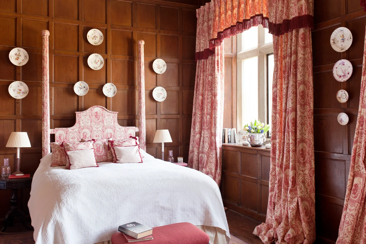 Bedroom with wooden wall panelling and decorative china plates