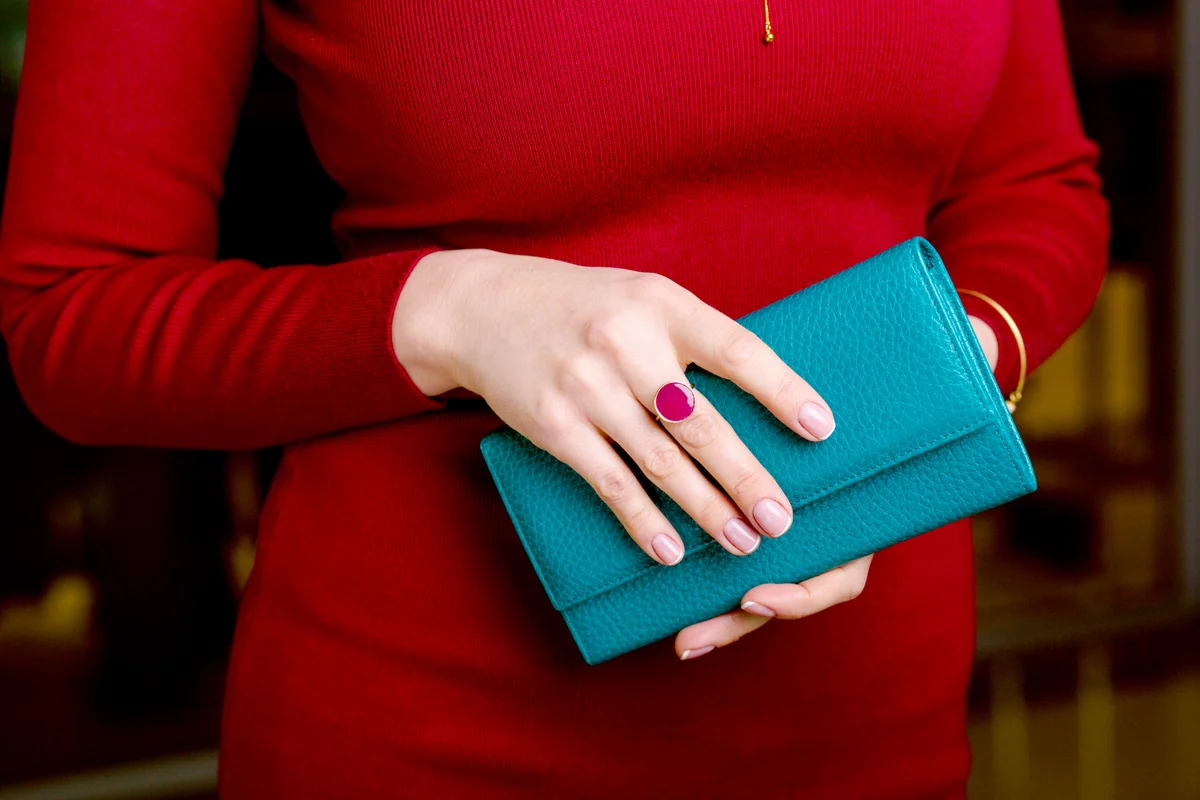 Woman dressed in red holding a blue wallet