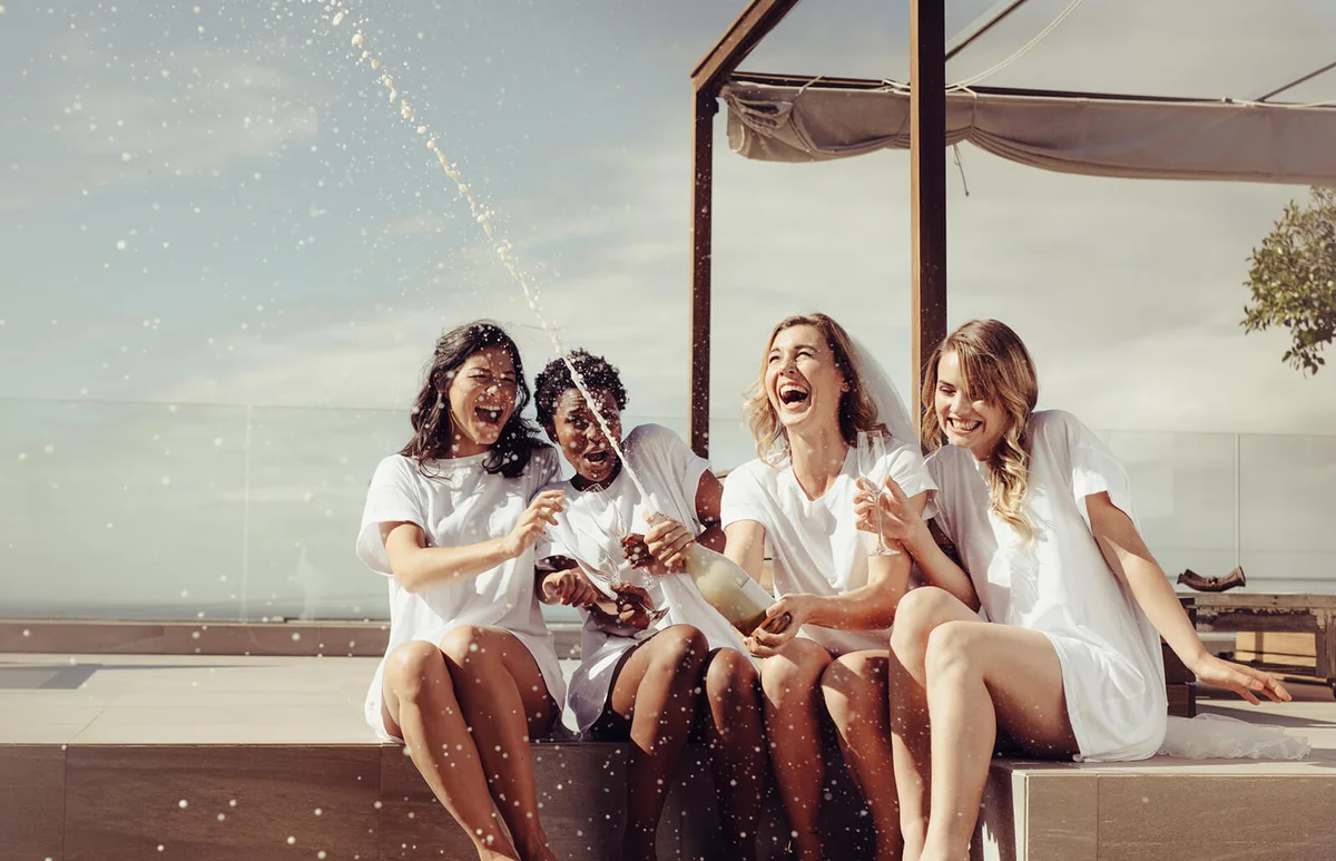 Cheerful bride and bridesmaids celebrating hen party