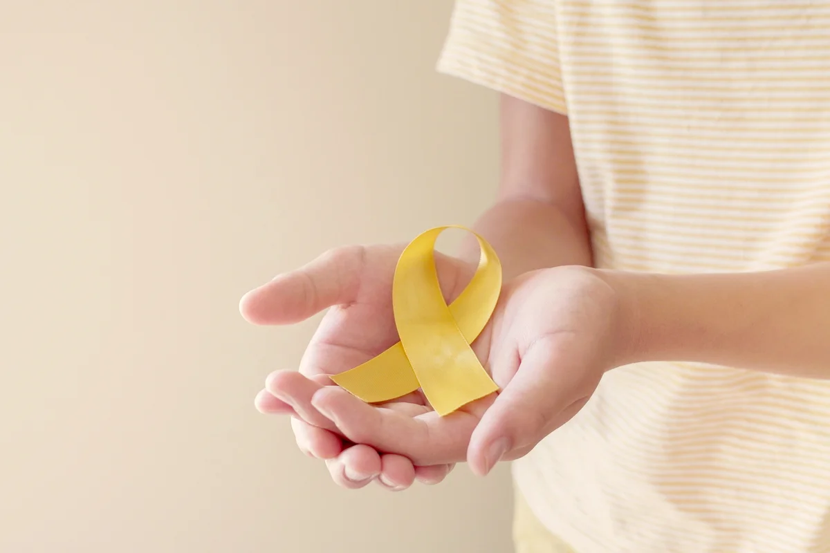 Hands holding yellow gold ribbon