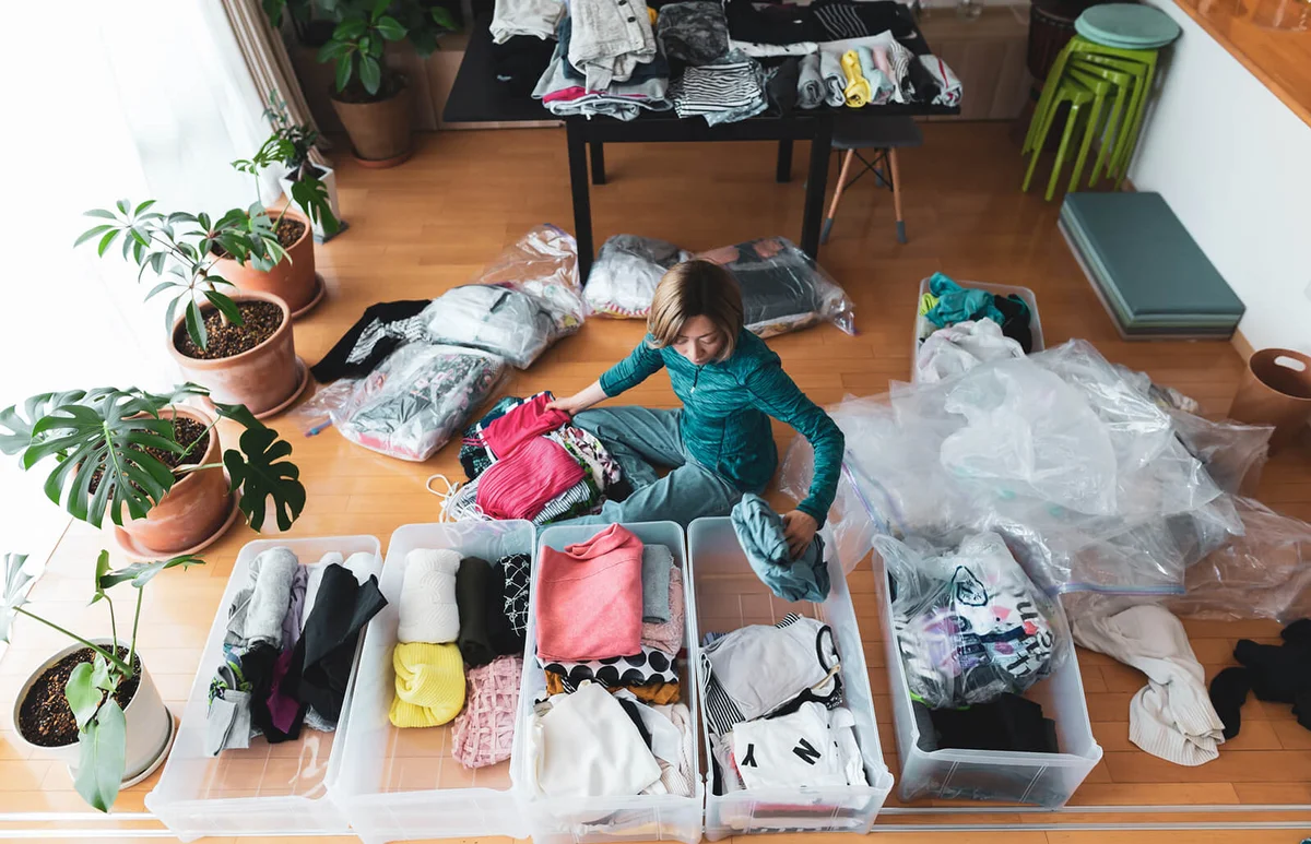 Woman organizes clothes in living room of her home