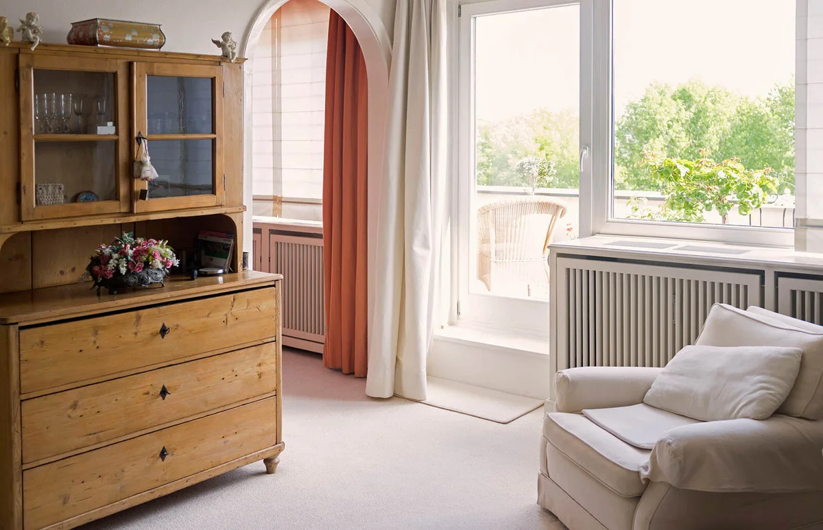 Living room with armchair and old cupboard -