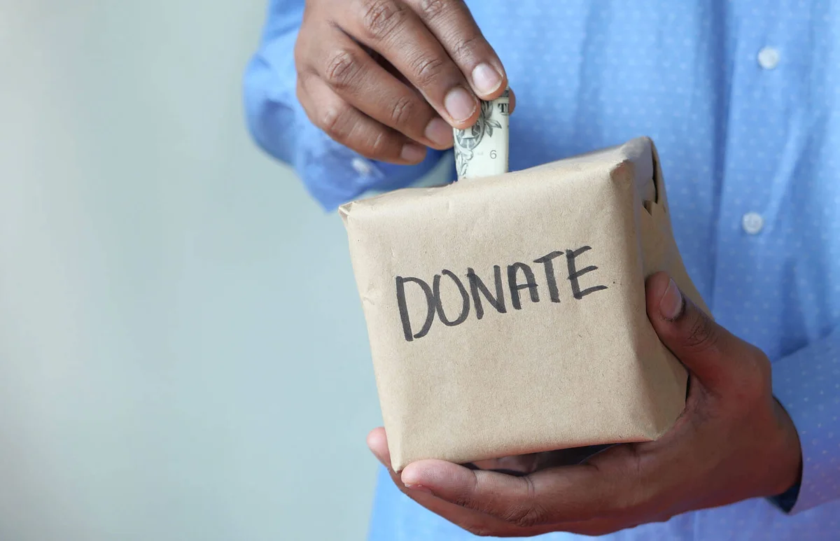 man puts money in donation box