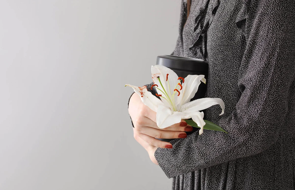 Woman with mortuary urn and lily flower