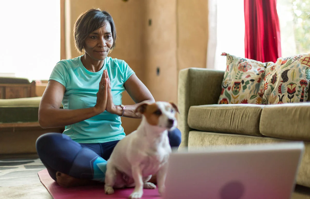 Mature woman doing yoga with an on-line tutorial
