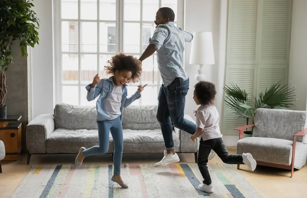 father son and daughter listening music dancing at home