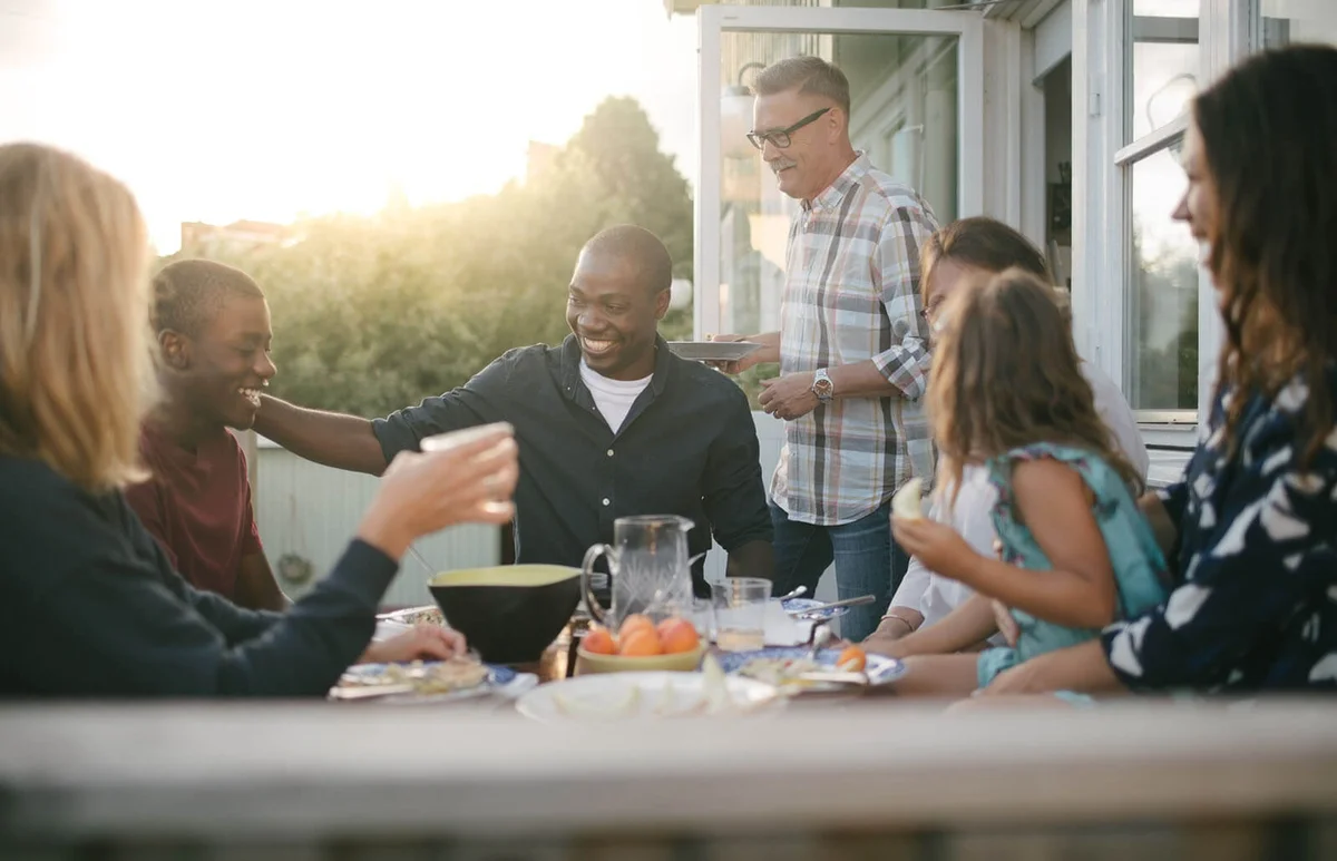 Cheerful multi-generation family enjoying lunch at porch