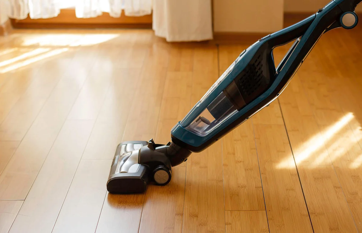 Vacuum cleaner cleaning bamboo flooring in a room