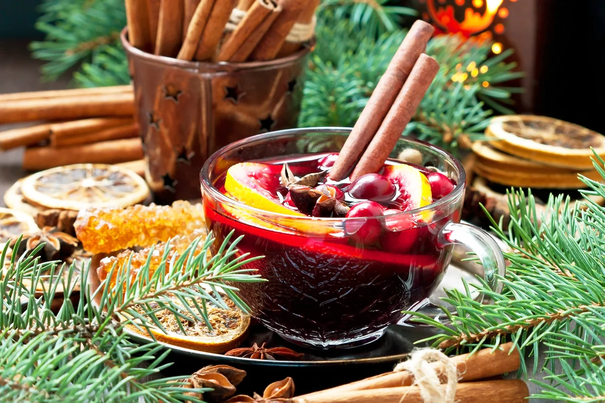 Christmas hot drink with citrus and cranberry in glass mug