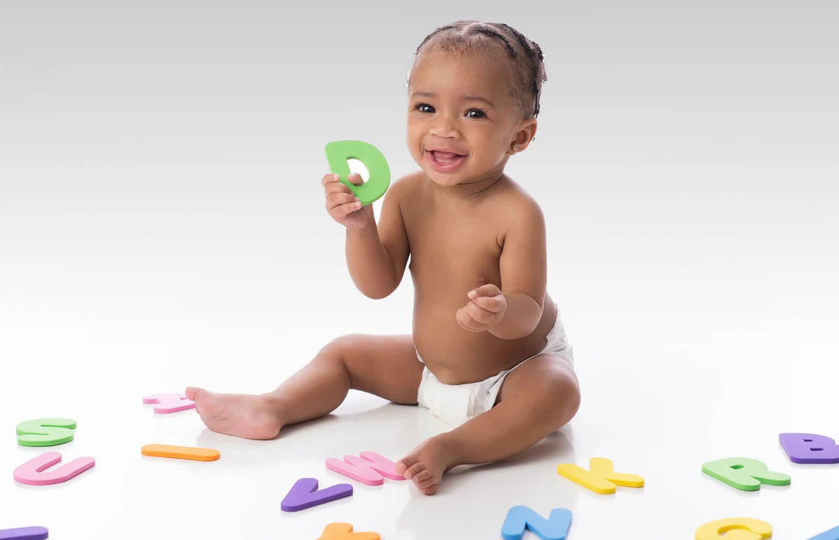 Smiling Baby Girl Playing with Letter Toys