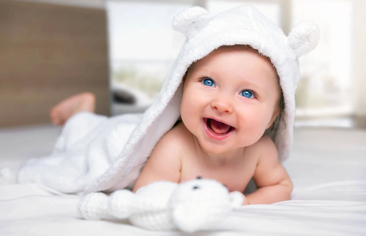 Cute Baby Smiling While Lying On Bed