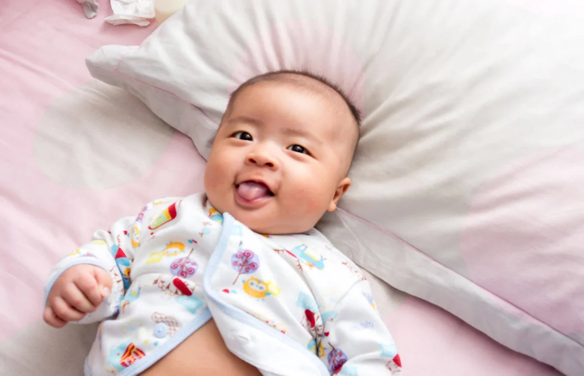 Baby Boy on Bed with Tongue Sticking Out