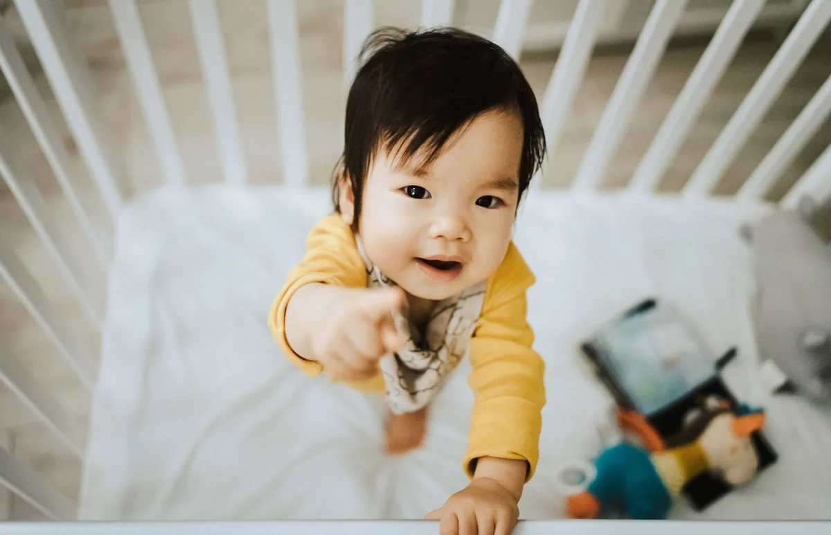 baby girl standing in her crib