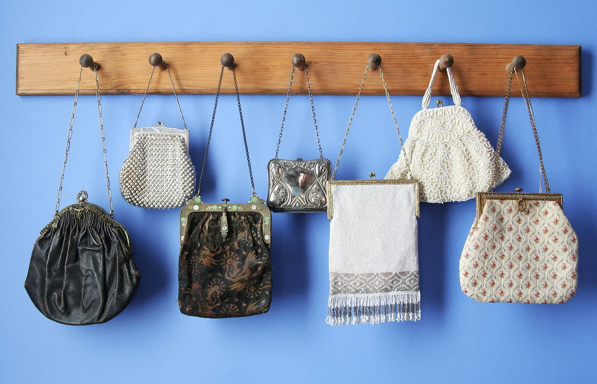 antique purses hanging from wooden pegs