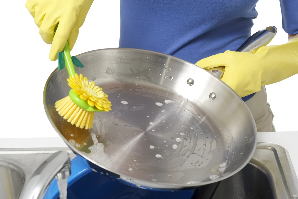 Woman washing stainless pan